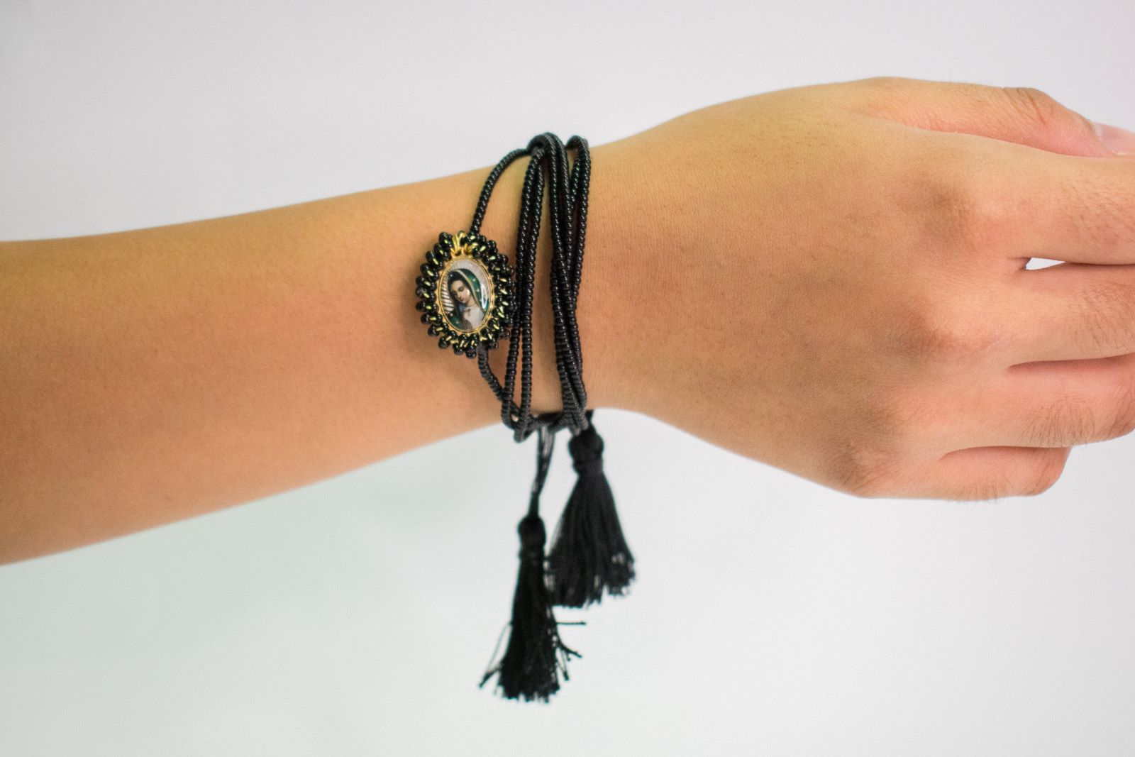 Pulsera negra de tres con ilustración de la virgen.